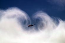DC-8 cuts through low clouds.